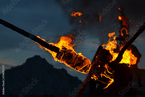 Detail of flames and smoke burning torches. View at dusk, darkness, in the background mountain mountains.