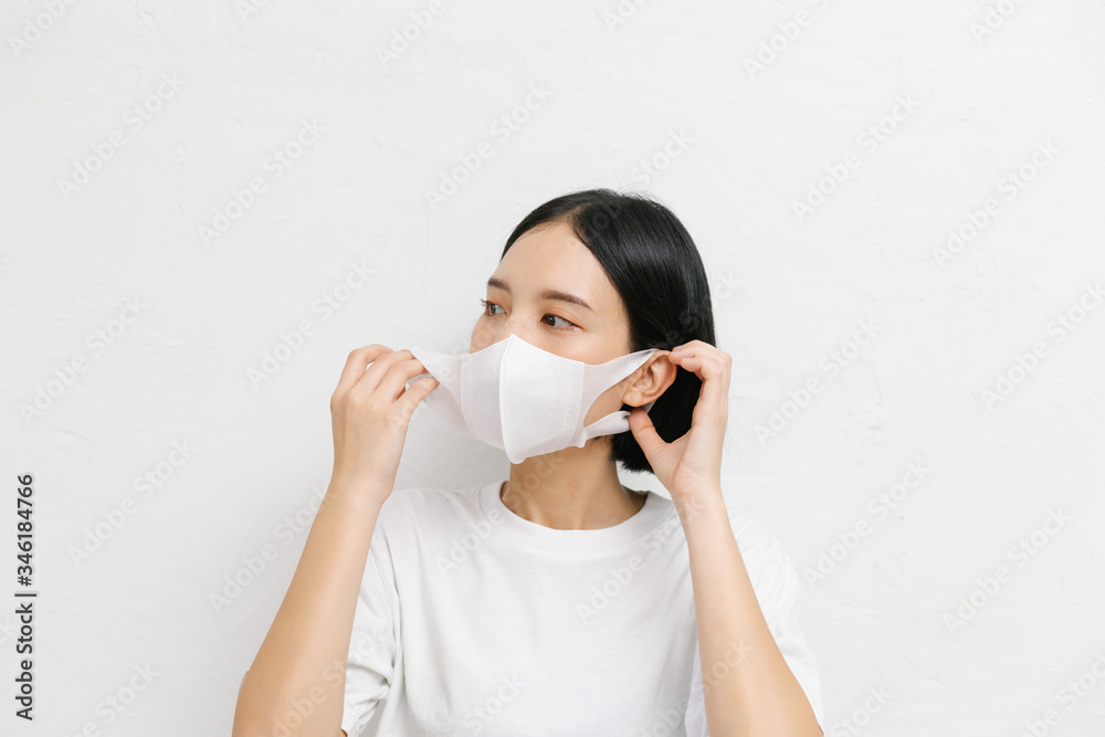 Young asian female wearing medical face mask to protect corona virus, studio portrait.
