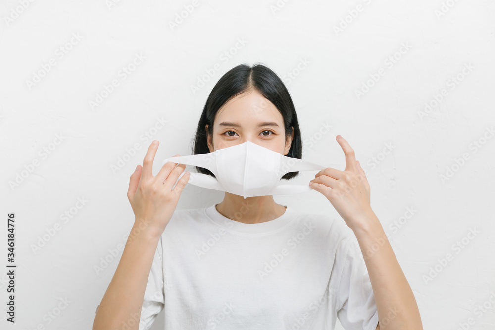 Young asian female wearing medical face mask to protect corona virus, studio portrait.