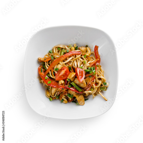 Fried udon noodles in a wok with chicken fillet and green beans. Traditional asian food.