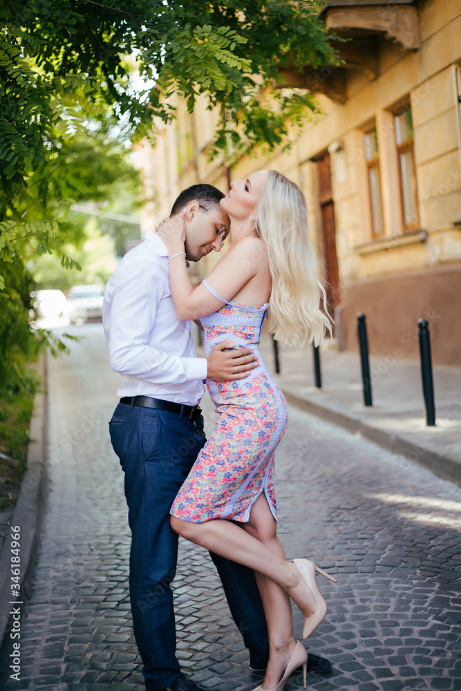 Young couple in love hug each other on city background