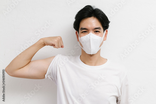 Young asian healthy male wearing medical face mask to protect corona virus, studio portrait.