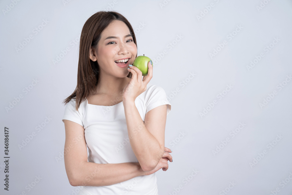 Young Asian happy smiling woman with green apple, isolated on white background. Young Asian happy smiling woman with green apple, isolated on white background.