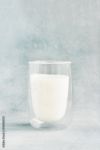 Glass of milk on blue background. Recipe of Korean drink latte with foam of instant coffee. DIY, instruction.