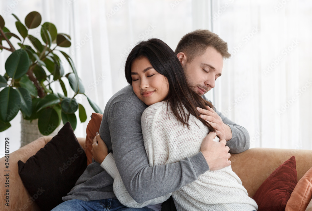 Multicultural Couple Hugging Reconciling After Quarrel At Home Multicultural Couple Hugging Reconciling After Quarrel At Home