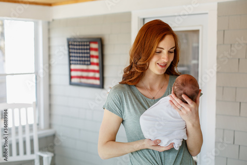 First time mom holding her newborn baby in American home.