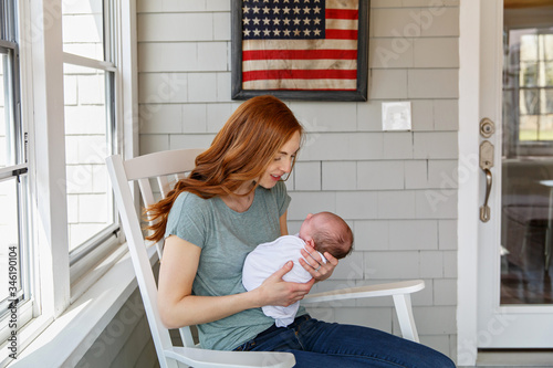 Mom admiring her newborn baby in American home. Military mom with a baby.