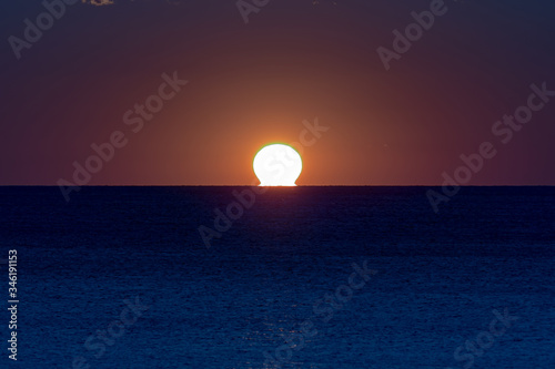Fototapeta Naklejka Na Ścianę i Meble -  Sunrise / sunset over the ocean horizon in tropical colors.