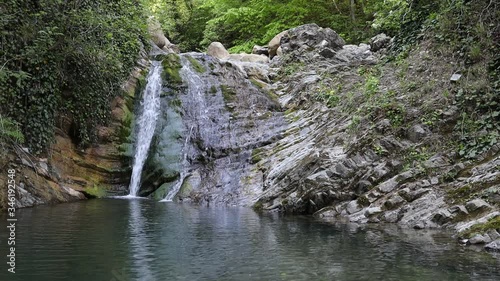 waterfall between rocks in a green forest