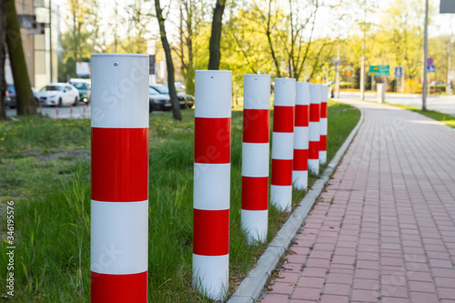 Red-white columns standing near the sidewalk.