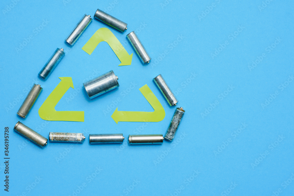 Scattered old dirty batteries aa or aaa size on blue background. Recycling concept. Save environment. Alternative energy Scattered old dirty batteries aa or aaa size on blue background. Recycling concept. Save environment. Alternative energy