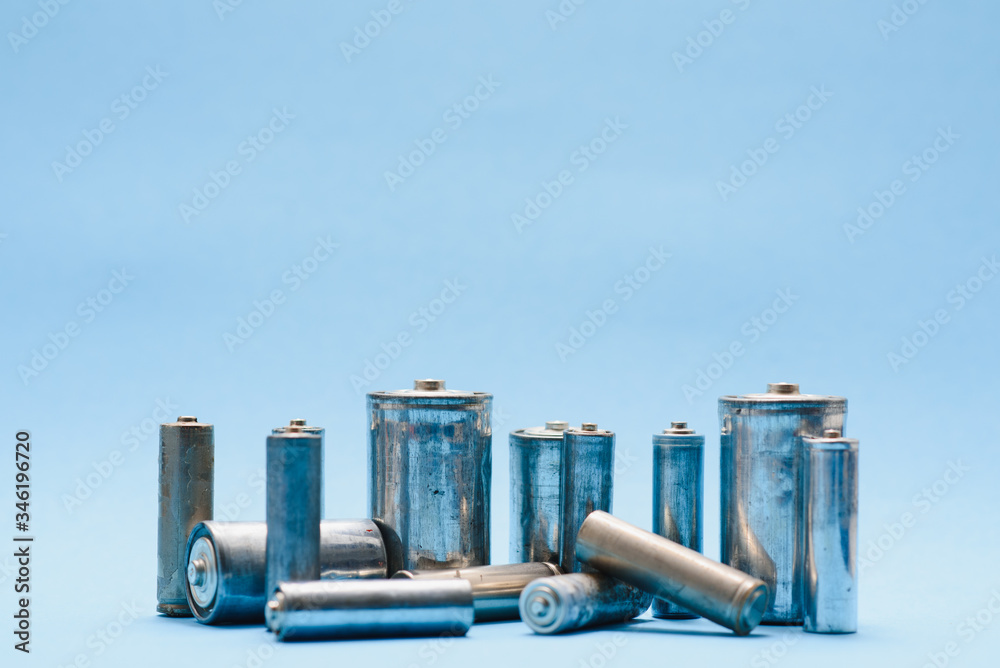 Obraz premium many used AA batteries on a blue background.
