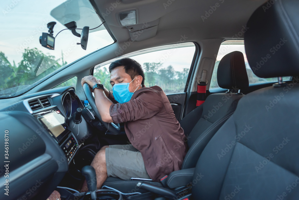 A man sat in a car and had a protective mask. A man sat in a car and had a protective mask.