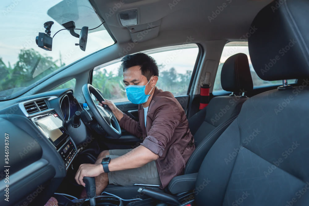 A man sat in a car and had a protective mask. A man sat in a car and had a protective mask.