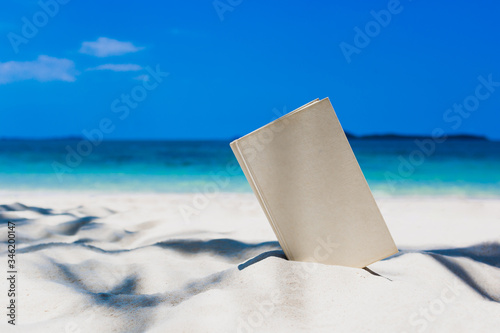 Fototapeta Naklejka Na Ścianę i Meble -  Book on the Beautiful ocean beach On the outdoor blurred sea background