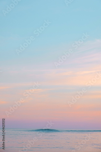 Expanse of the ocean against the sunset sky. Gorgeous pink  lilac sunset over the quiet expanse of the sea with wave. Fantastic seascape. Natural composition.