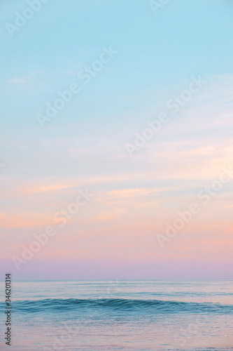Expanse of the ocean against the sunset sky. Gorgeous pink, lilac sunset over the quiet expanse of the sea with wave. Fantastic seascape. Natural composition. © EVISUAL