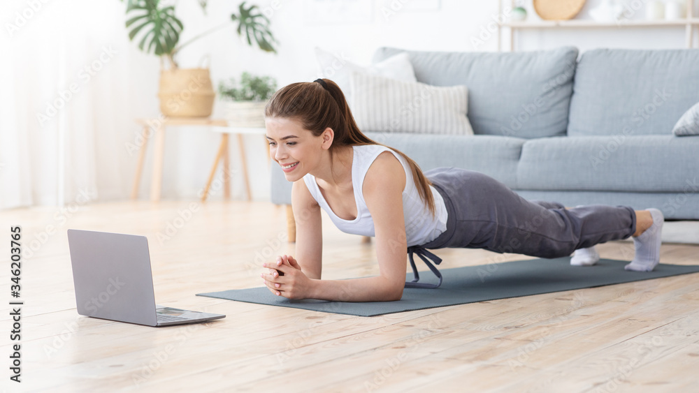 Positive girl planking at home, doing morning exercise Positive girl planking at home, doing morning exercise