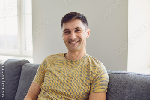 Fototapet Businessman in casual t-shirt serious looking at the camera at home in the offic