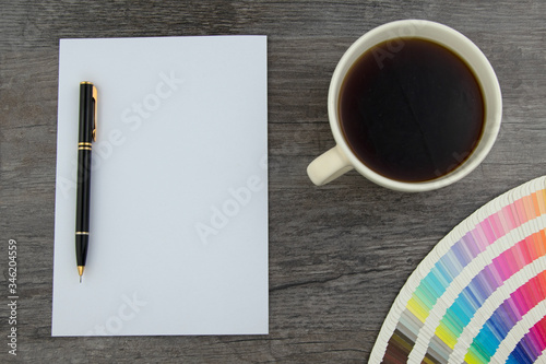 Top view of empty white page, elegant pencil and designers color range with coffee cup