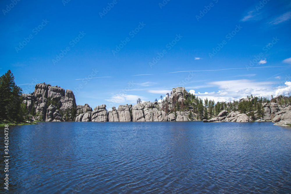 Sylvan lake in Custer state park black hills United States of America. Blue lake and blue sky with rocks and green trees. Travel background with nature view on lake South Dakota national forest.