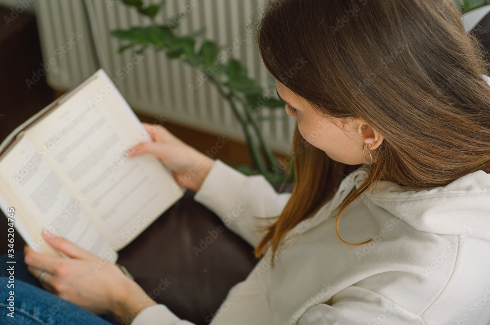 Reading and development. Beauty young woman is reading a book at home. Thoughtful girl reading important book Reading and development. Beauty young woman is reading a book at home. Thoughtful girl reading important book