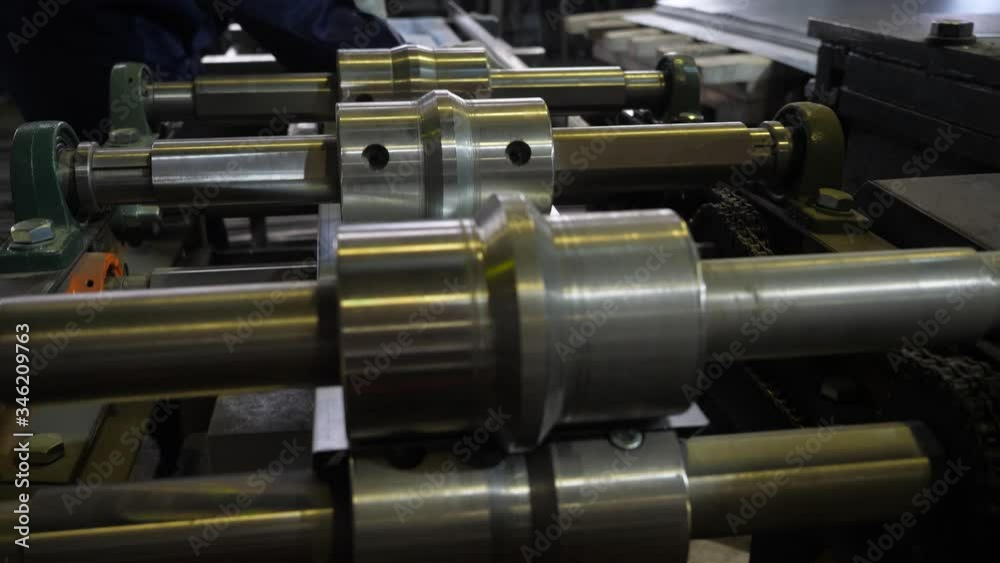 Metal rolling machine. A galvanized sheet of metal moves along the machine. Factory for the manufacture of metal products Metal rolling machine. A galvanized sheet of metal moves along the machine. Factory for the manufacture of metal products