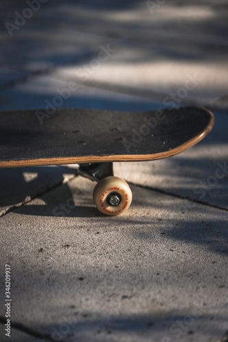 Detailaufnahme Skateboard auf Beton im Sonnenlicht mit Schatten