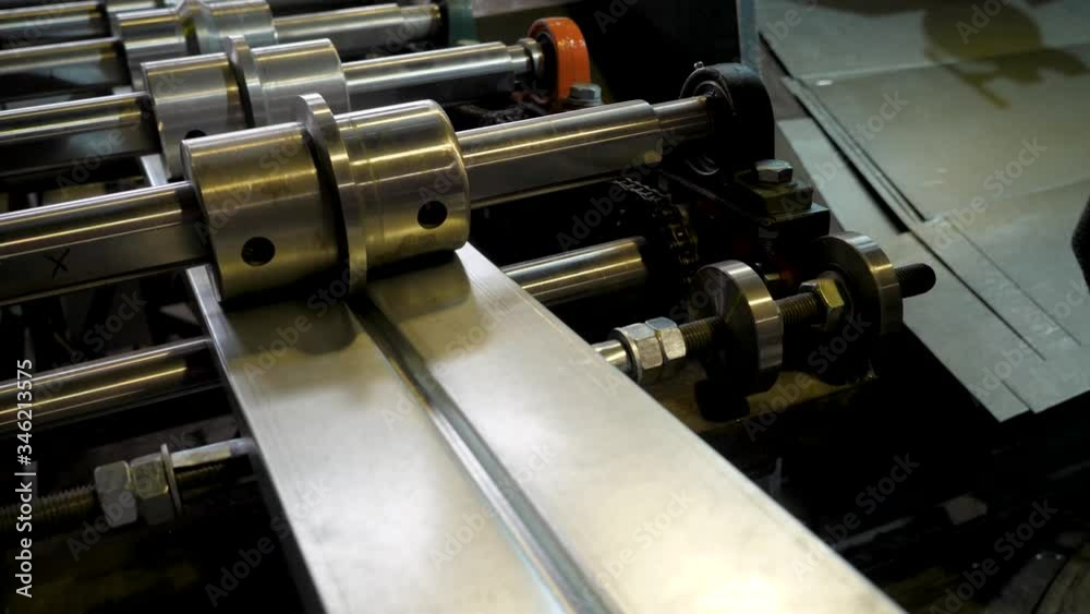 Metal rolling machine. A galvanized sheet of metal moves along the machine Metal rolling machine. A galvanized sheet of metal moves along the machine