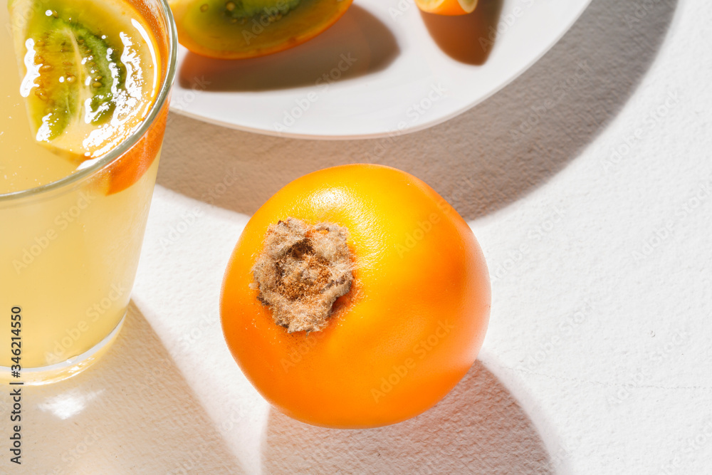 glass with juice and slices of lulo fruit, on the table glass with juice and slices of lulo fruit, on the table