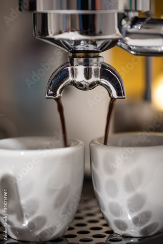 Close-up of brewing machinery pouring and  preparing espresso coffee
