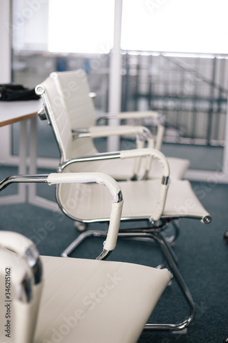 Metal chairs in a business room with white leather upholstery