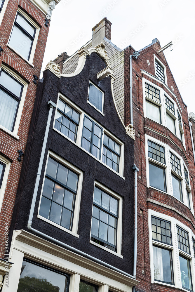 Fototapeta premium Old traditional leaning houses in Amsterdam, Netherlands