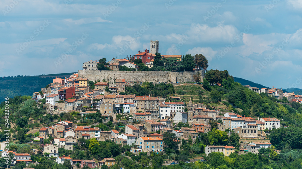 The ancient city of Motovun is located on the top of the mountain. The city is surrounded by a fortress wall. The background image are mountains and fog. Istria, Croatia. The view from the top