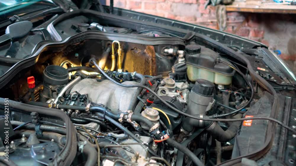 A professional mechanic repairs the car 's engine. Auto repair shop, car service, repair. A professional mechanic repairs the car 's engine. Auto repair shop, car service, repair.