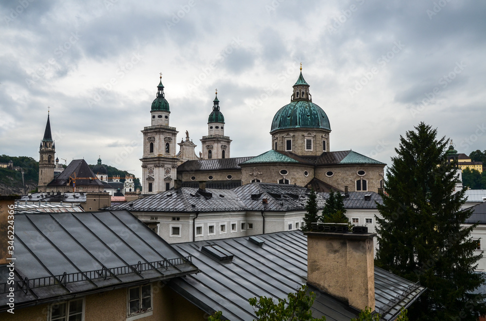 Rooftops buildings cityscape and  Roman Catholic Salzburg Cathedral (Dom zu Salzburg) at Residenzplatz square at rainy day