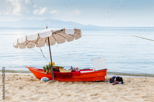 Mujer tailandesa echa la siesta a la sombra en playa paradisíaca. Estampa costumbrista photo