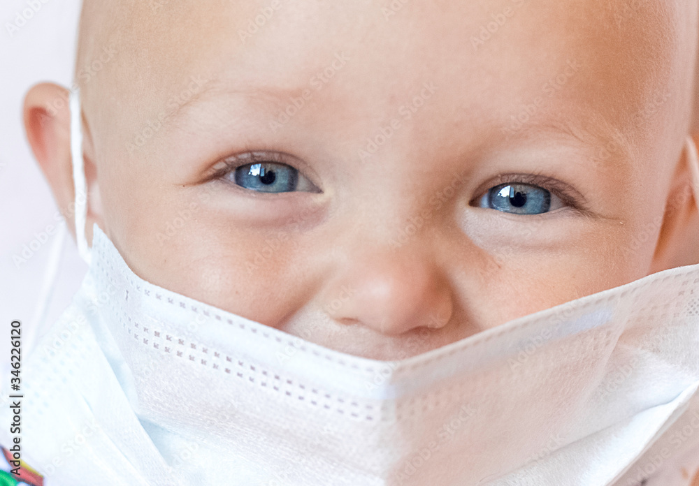 little girl with a mask. Baby face in surgery mask closeup. Portrait of happy caucasian girl in white medical mask that close her mouth