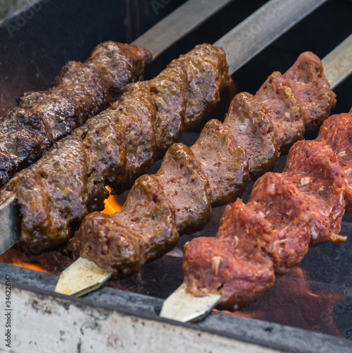 Adana kebab (ground lamb minced meat on skewer on grill over charcoal).
