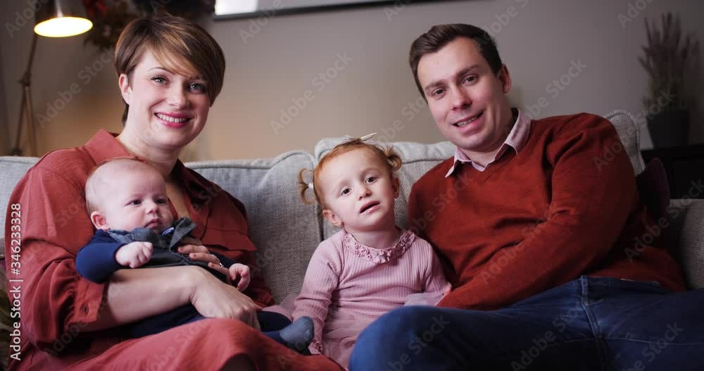 Portrait of happy family sitting on sofa at home Portrait of happy family sitting on sofa at home