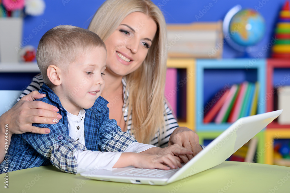 Close-up portrait of mother and son using laptop together Close-up portrait of mother and son using laptop together