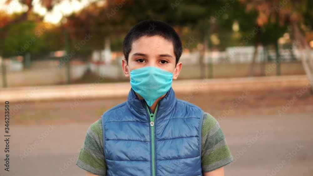 boy covering his face with blue mask, mouth cover in the face of the world pandemic of the covid-19 coronavirus
