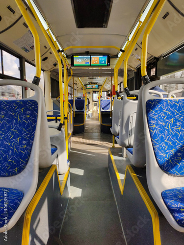 Empty bus.  Translation of text on the screen: weather forecast for today, tuesday, morning, afternoon - cloudy, evening - cloudy
translation of text from a sticker: rules (for bus passangers)
