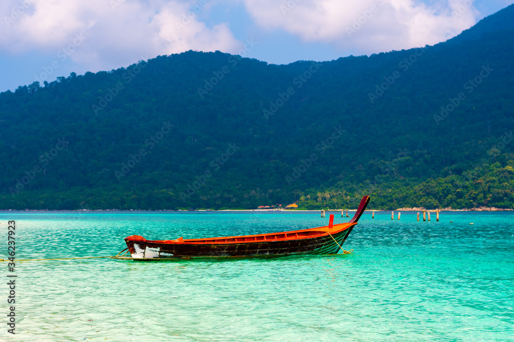 Long tail boat on the sea at Ko Lipe island, Thailand. Tropical island with white sand, beach and turquoise sea is part of Tarutao National Marine Park. Idyllic vacation, relaxation in paradise.