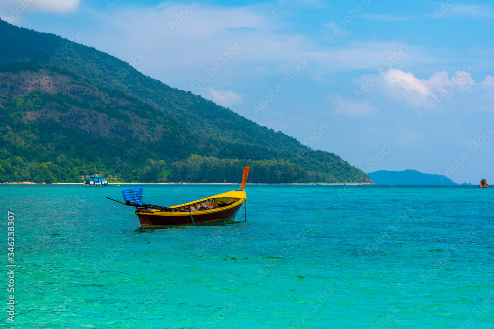 Long tail boat on the sea at Ko Lipe island, Thailand. Tropical island with white sand, beach and turquoise sea is part of Tarutao National Marine Park. Idyllic vacation, relaxation in paradise.