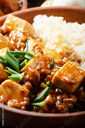 Authentic traditional Chinese food mapo tofu dish with pork chives and steamed rice closeup