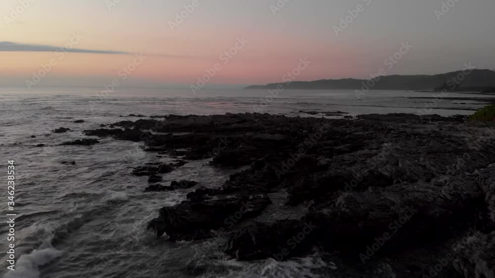 Rocky Shore In Costa Rica Coast With Waves Splashing At Dusk - aerial drone shot Rocky Shore In Costa Rica Coast With Waves Splashing At Dusk - aerial drone shot