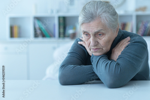 Portrait of sad senior woman sitting at table