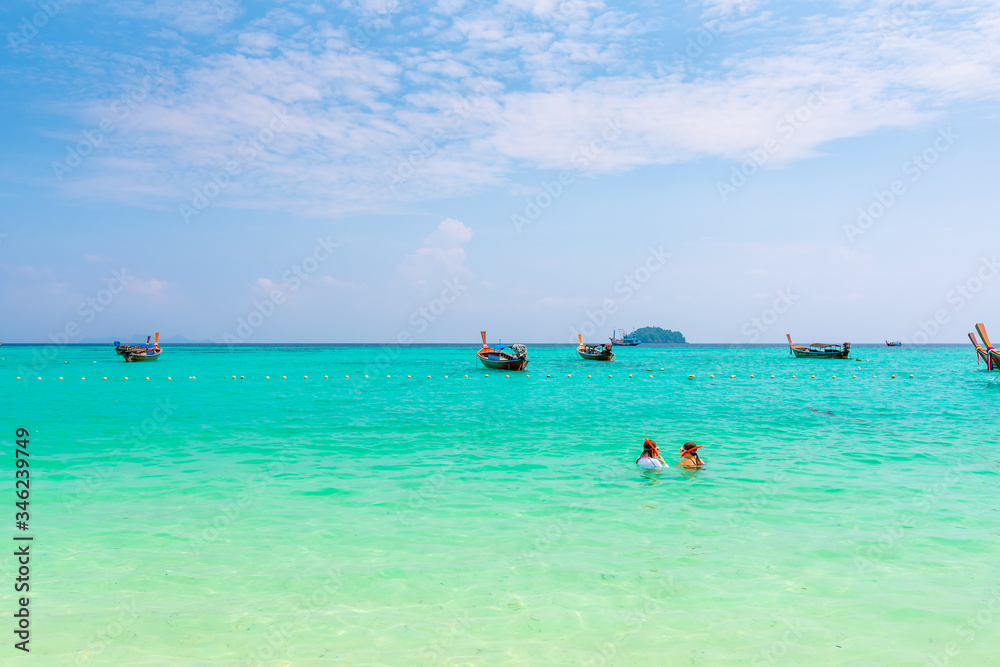 Two unidentifiable girls are snorkeling at Ko Lipe island, Thailand. Turquoise sea, pure water and coral reef with many tropical and exotic animals. Two unidentifiable girls are snorkeling at Ko Lipe island, Thailand. Turquoise sea, pure water and coral reef with many tropical and exotic animals.