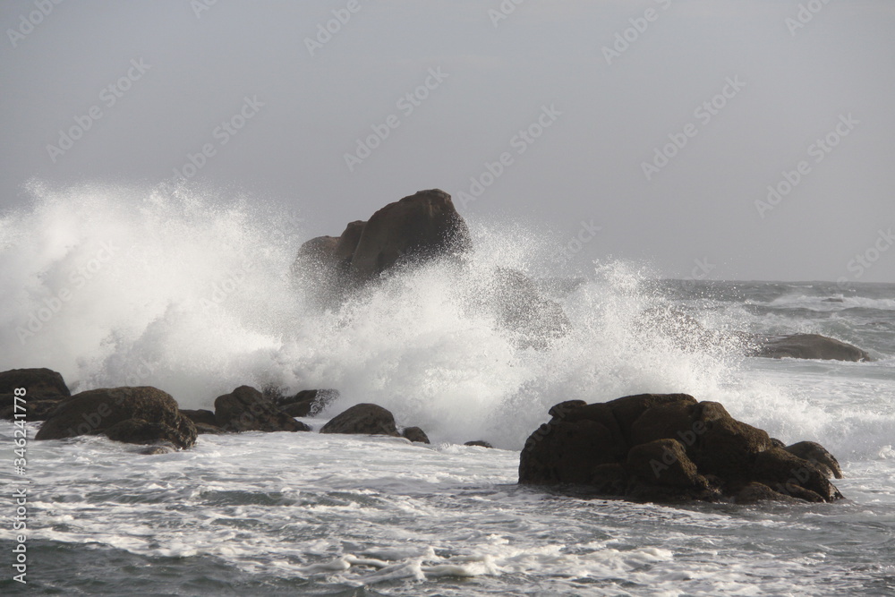 waves crashing against a rocky outcrop in shallow water